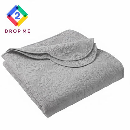 Folded gray paisley cotton quilt showing scalloped trim – lightweight, soft, and machine washable 🧺